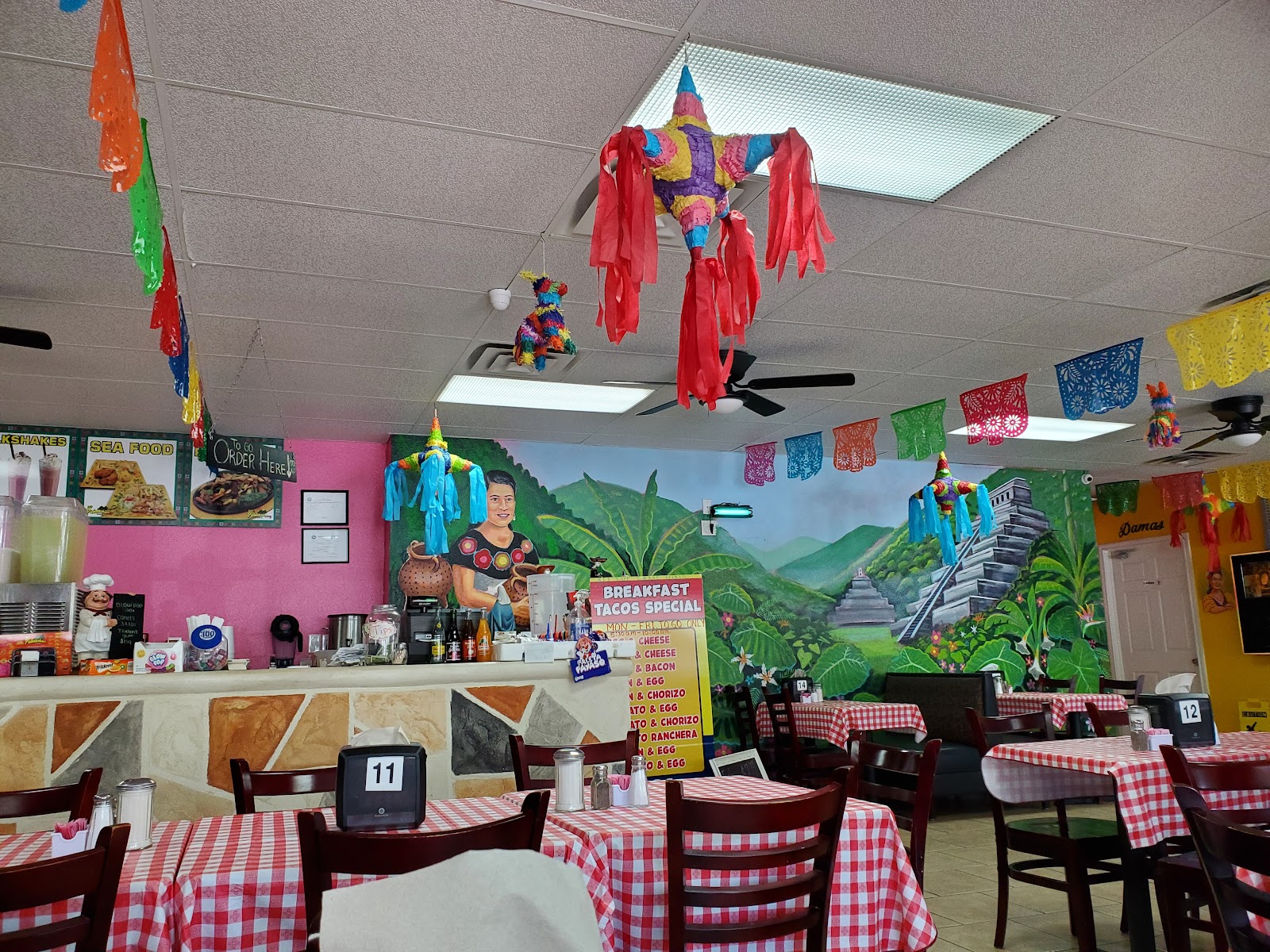 Colorful mural and pi&ntilde;atas inside Las Pichanchas Cafe #2 dining room